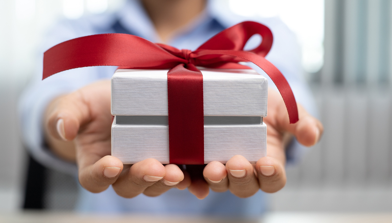 Girl Holding a Small Gift with a Red Ribbon